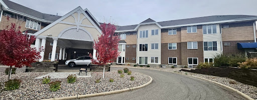 A modern apartment building with autumn foliage and well-maintained landscaping.