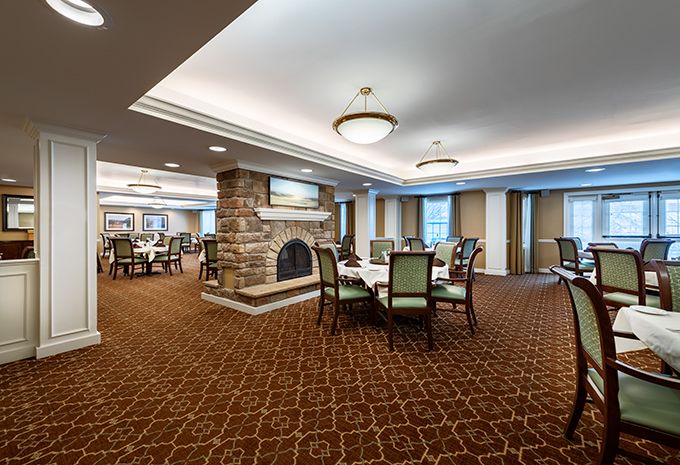 A spacious dining room with elegant furnishings and a cozy fireplace.