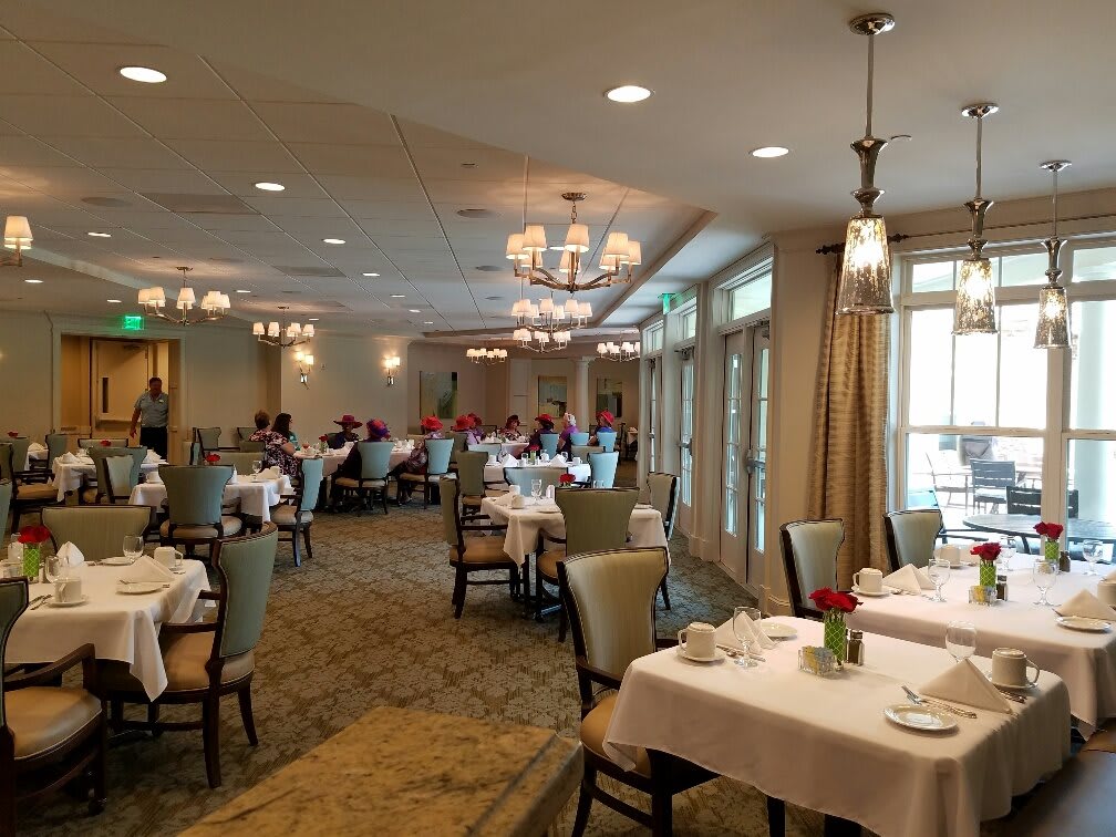 An elegant dining room with neatly arranged tables and chairs, featuring soft lighting and tasteful decor.
