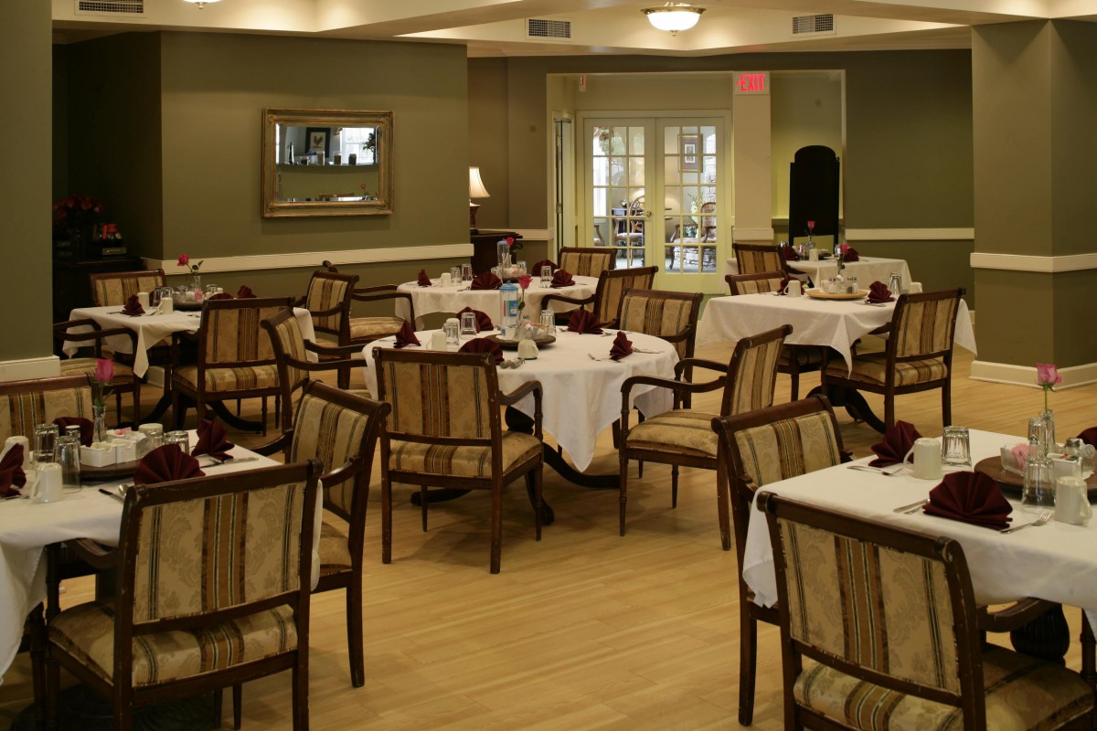 An empty restaurant dining room with neatly arranged tables and chairs.