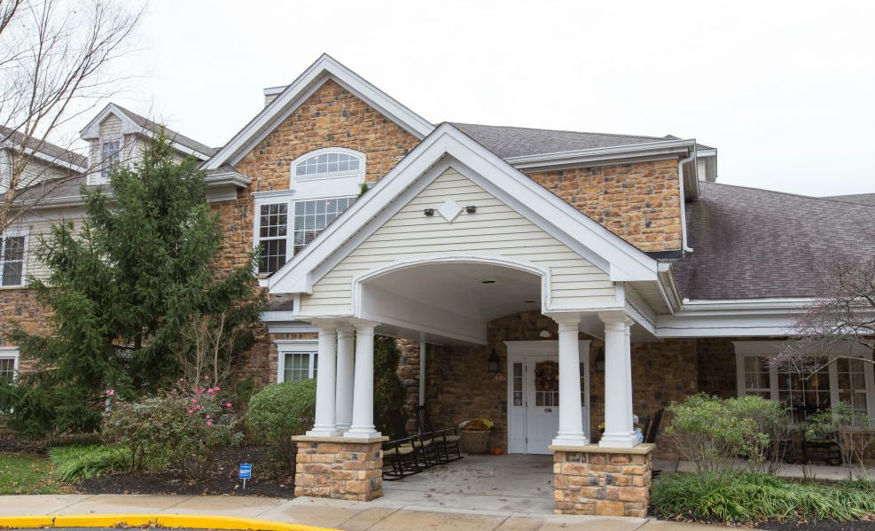 A brick building with a covered entrance and white columns.