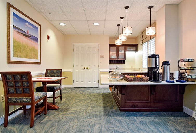 A cozy kitchen and dining area with modern lighting, seating, and a coffee station.