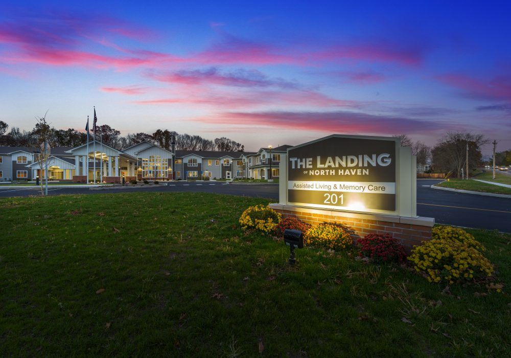 An apartment complex with a prominent sign at sunset.