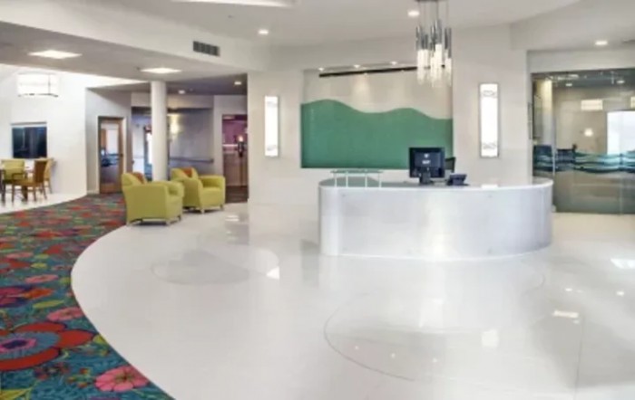 A bright and modern hotel lobby with a reception desk and comfortable seating.