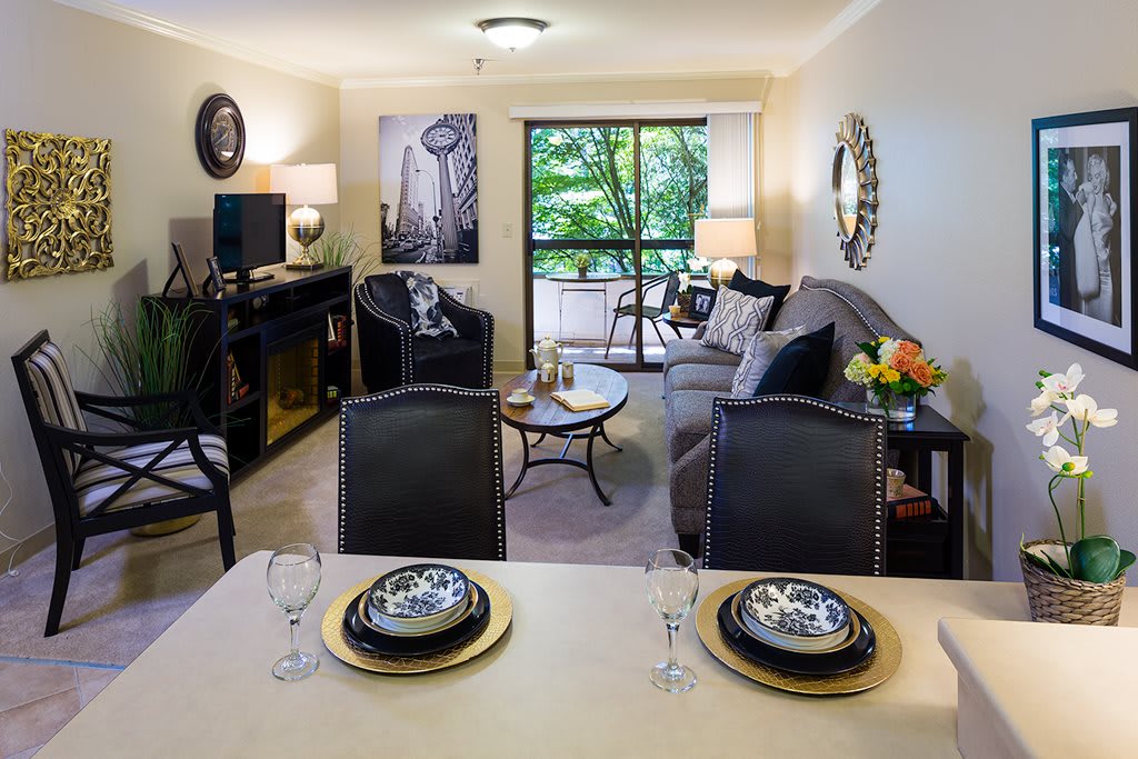 A modern and elegantly decorated living room and dining area with tasteful furnishings.