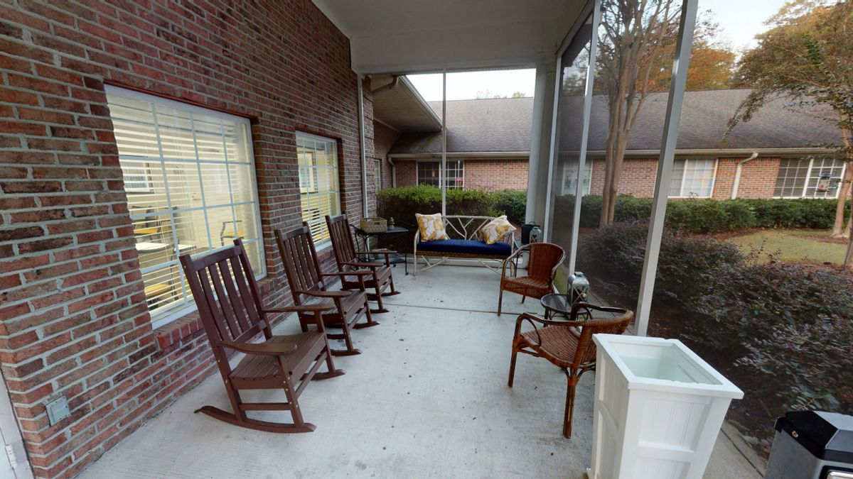 A cozy porch featuring rocking chairs and a cushioned bench, perfect for relaxation.