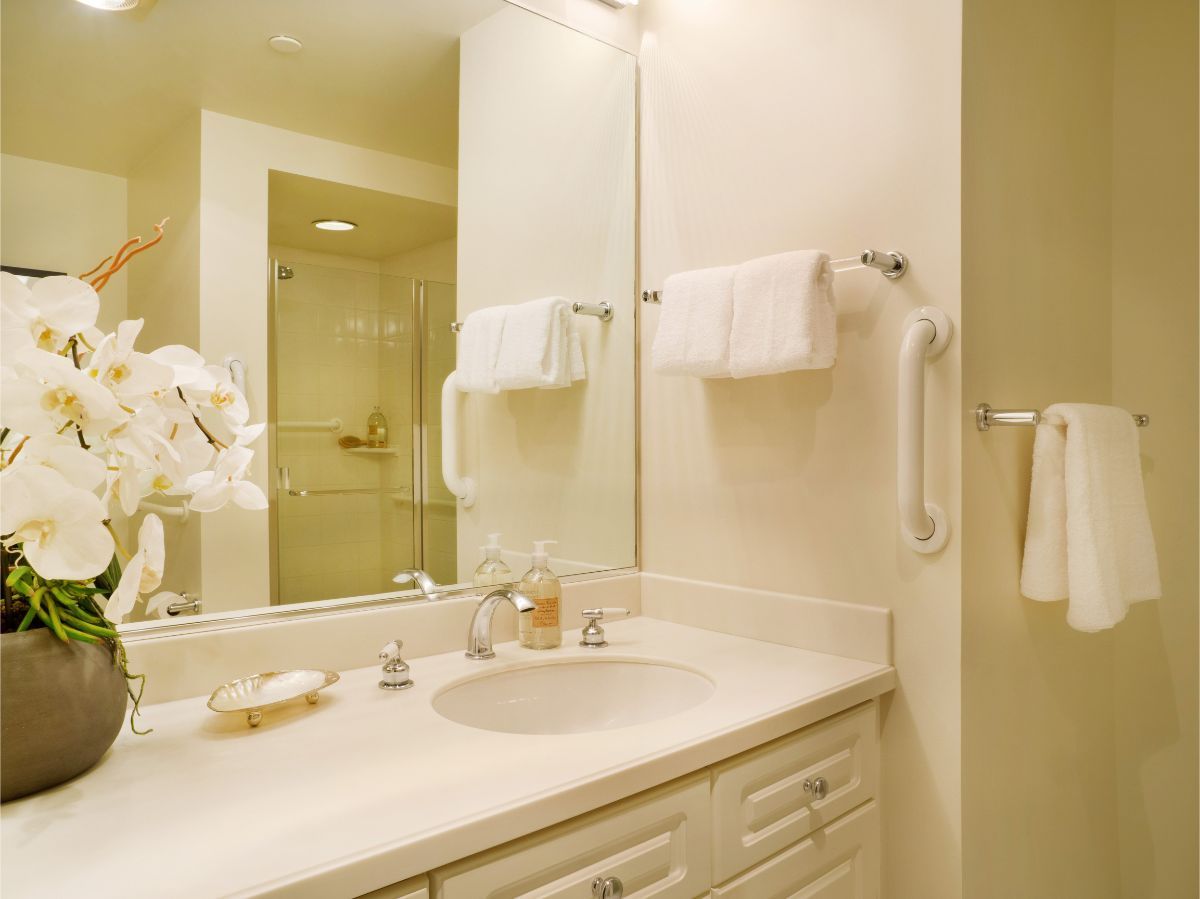 A luxurious bathroom featuring a large mirror, elegant countertop, and neatly arranged towels.