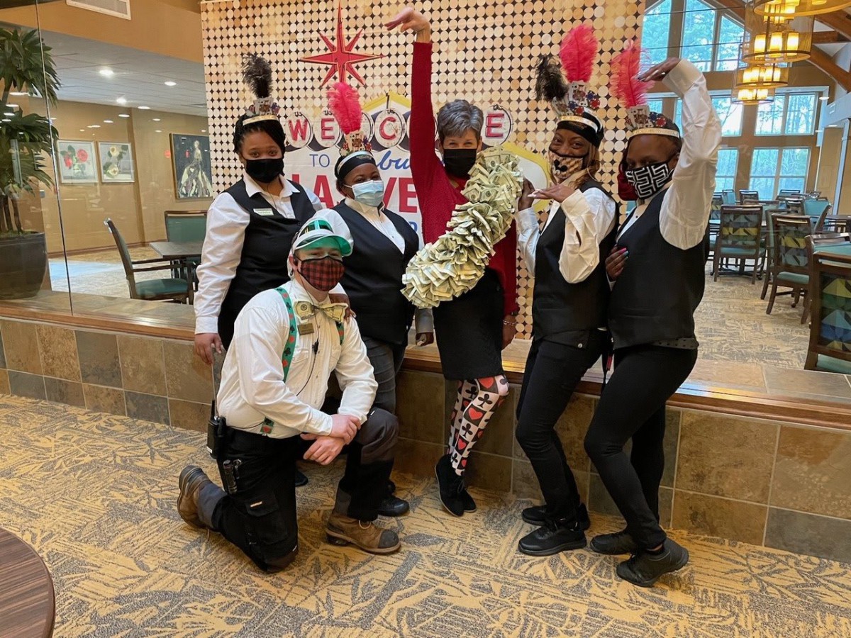 A group of people in colorful costumes posing indoors, celebrating a festive event.
