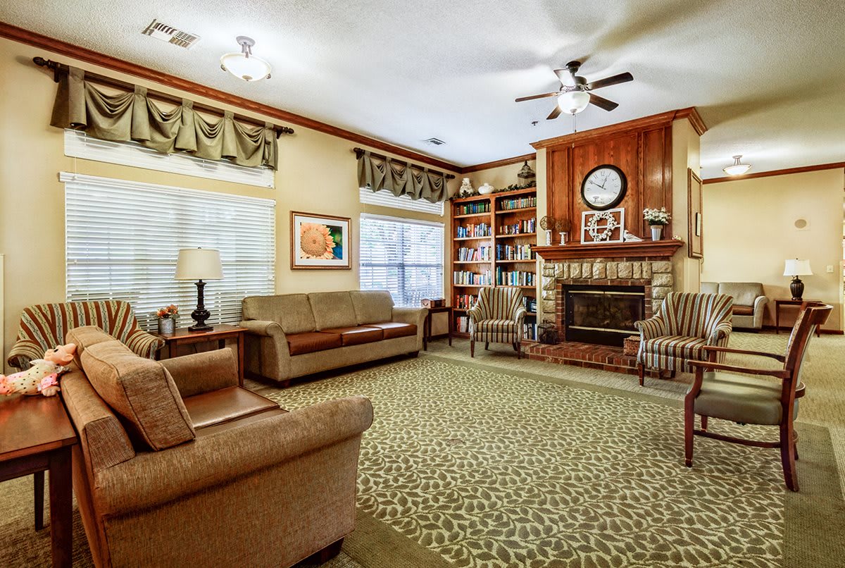 A cozy living room with a classic design, featuring a fireplace and bookshelf.