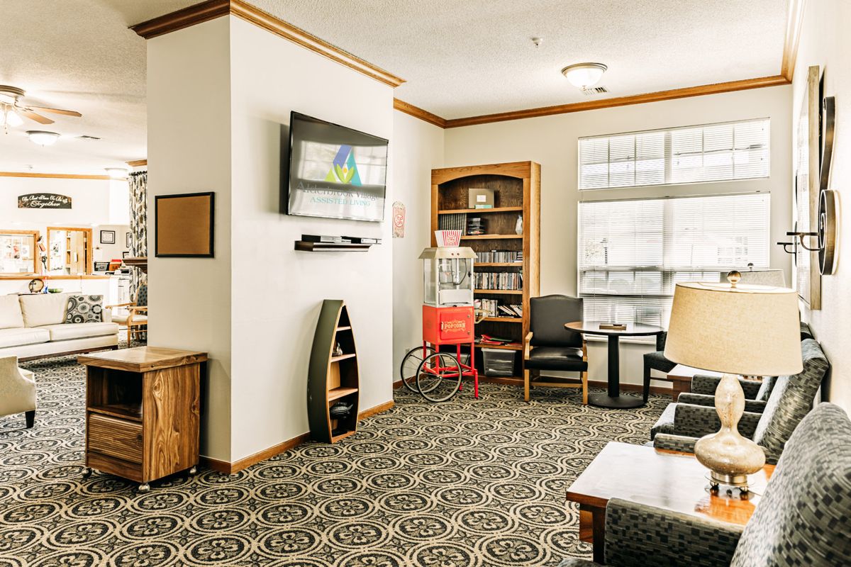 A cozy living room with a television, bookshelf, and comfortable seating.