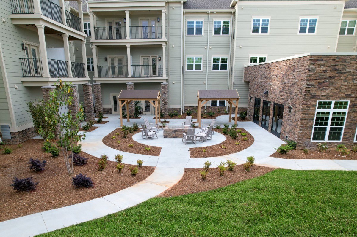 A well-landscaped courtyard with outdoor seating at an apartment complex.