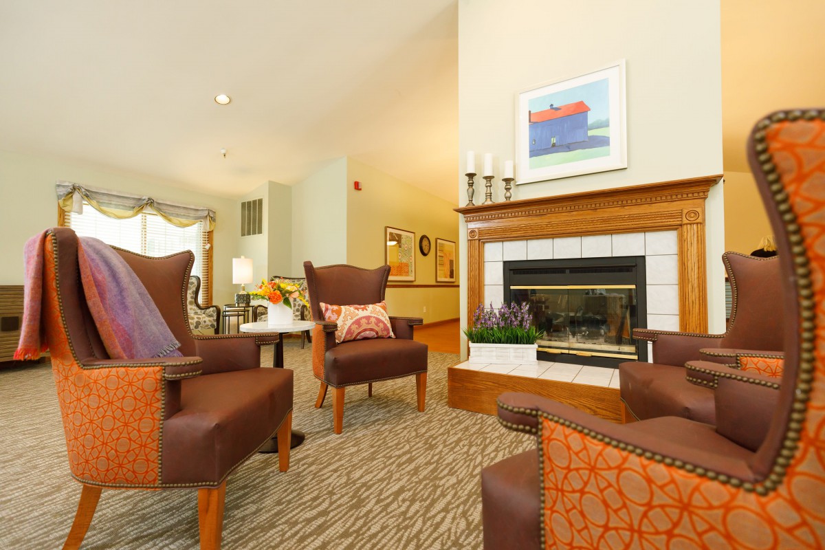 A cozy living room with comfortable chairs and a warm fireplace.