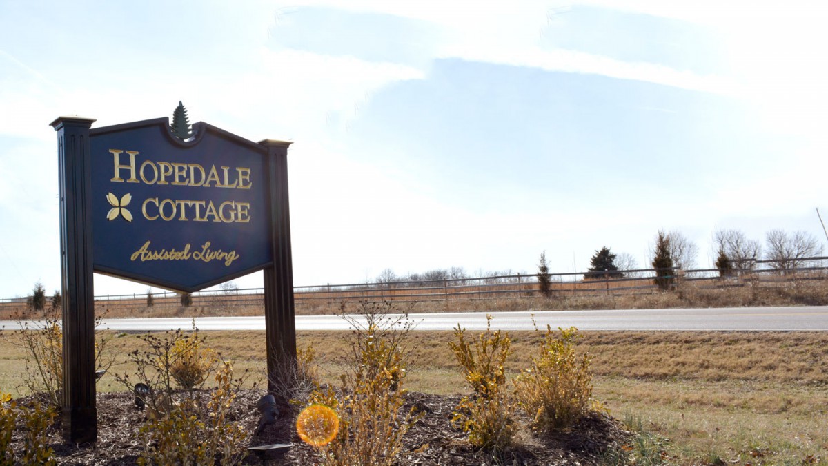A roadside sign in a rural landscape on a sunny day.
