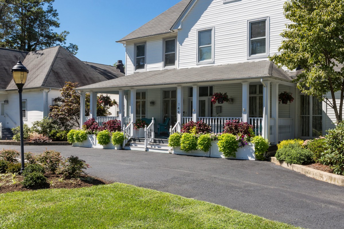 A charming house with a spacious front porch and well-maintained garden.