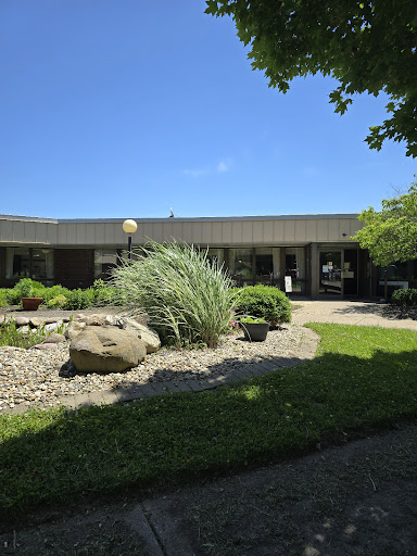 A scenic view of a modern building surrounded by well-maintained landscaping and greenery.