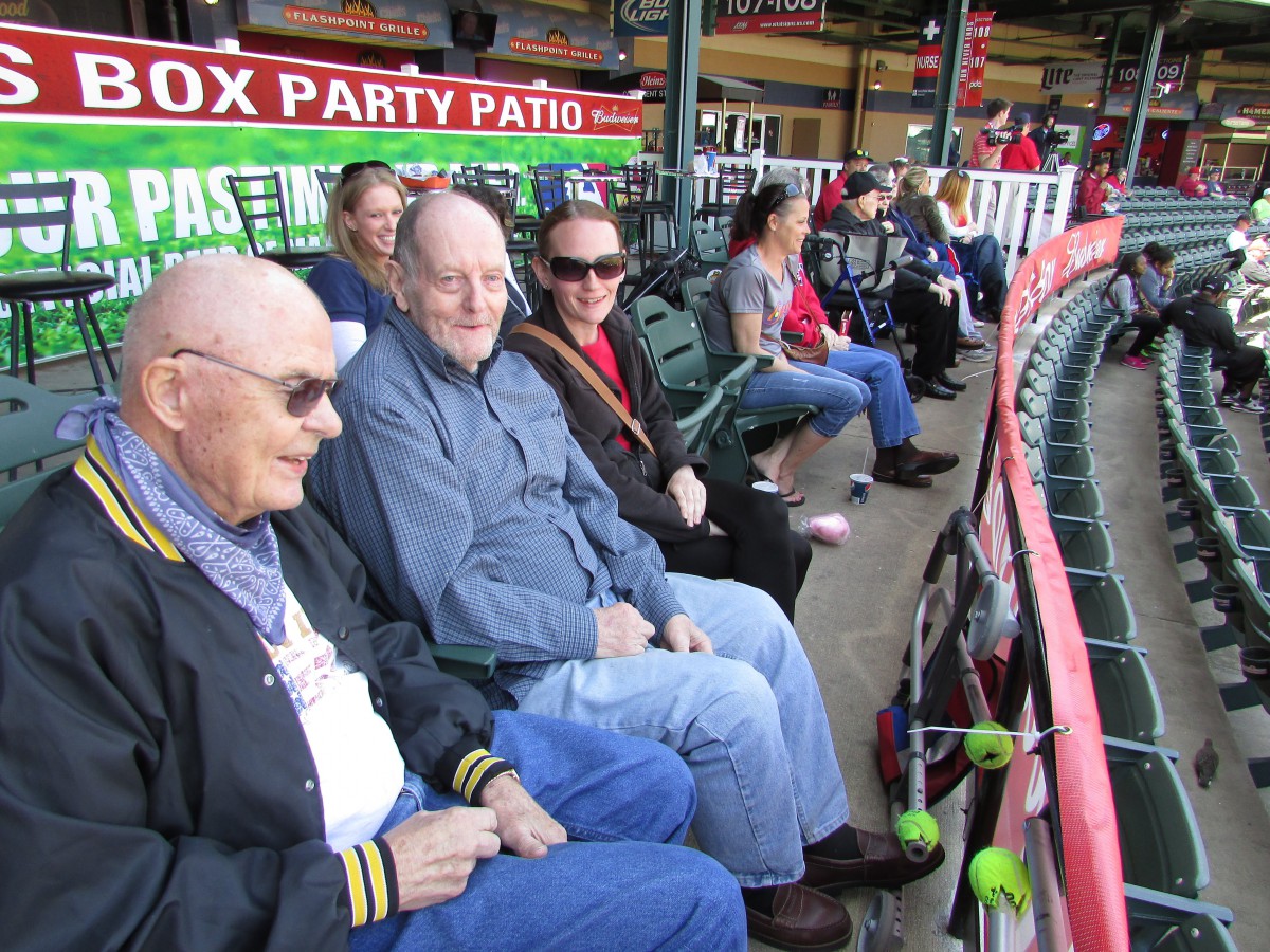 A group of people sitting in a stadium, enjoying a baseball game.