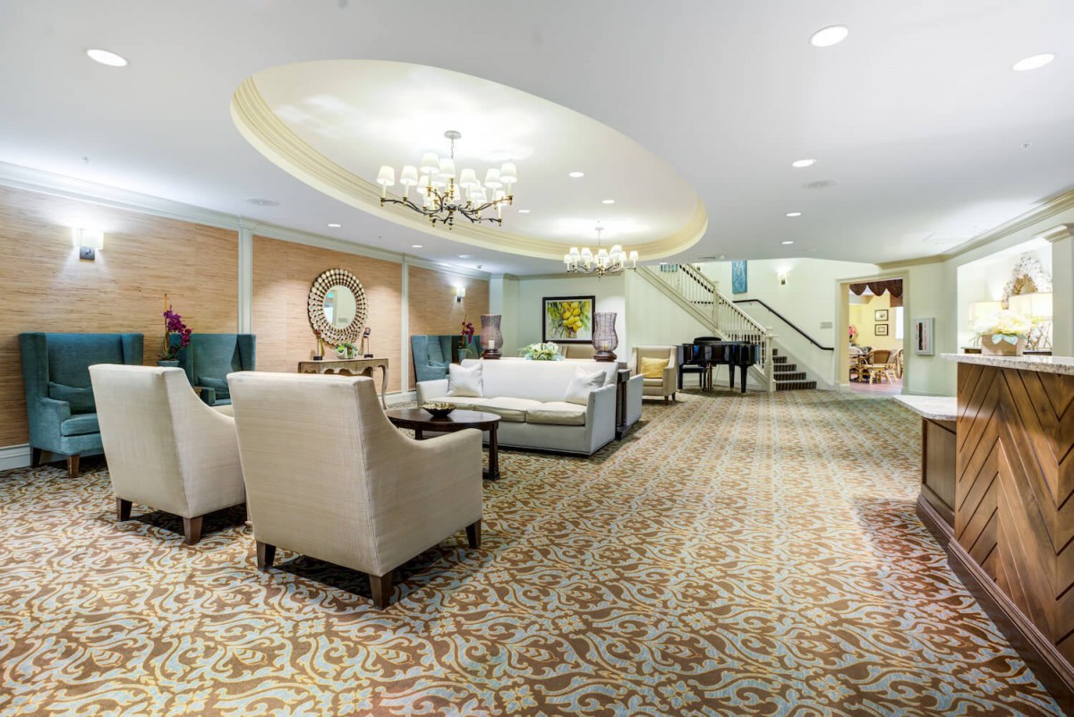 Elegant hotel lobby with a chandelier and comfortable seating area.