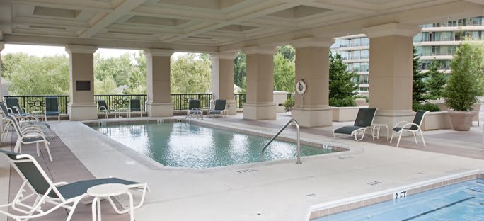 A luxurious indoor swimming pool with surrounding lounge chairs and greenery.