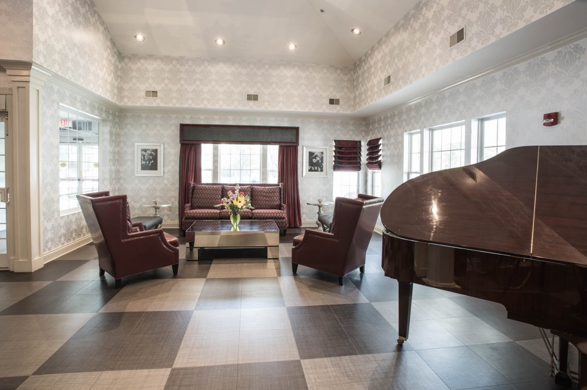 A stylish lounge area with a grand piano and elegant furniture.