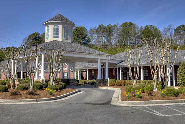 A well-maintained building with a circular driveway and landscaped surroundings.