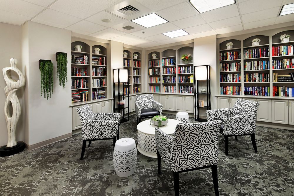 A modern library with comfortable seating and shelves filled with books.