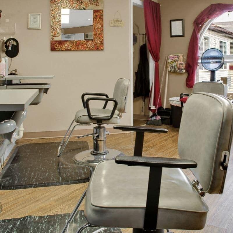 An interior view of a barbershop with chairs and mirrors.