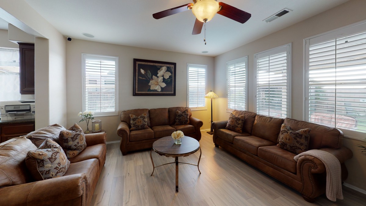 A cozy living room with comfortable sofas, a central coffee table, and warm lighting.