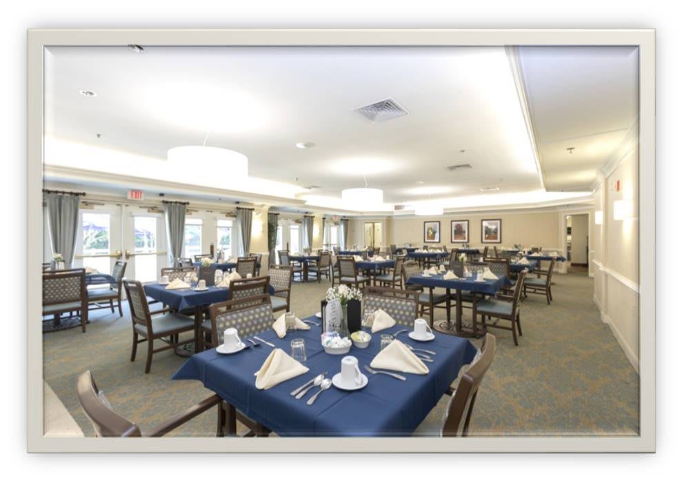 A spacious dining room with neatly arranged tables and elegant table settings.