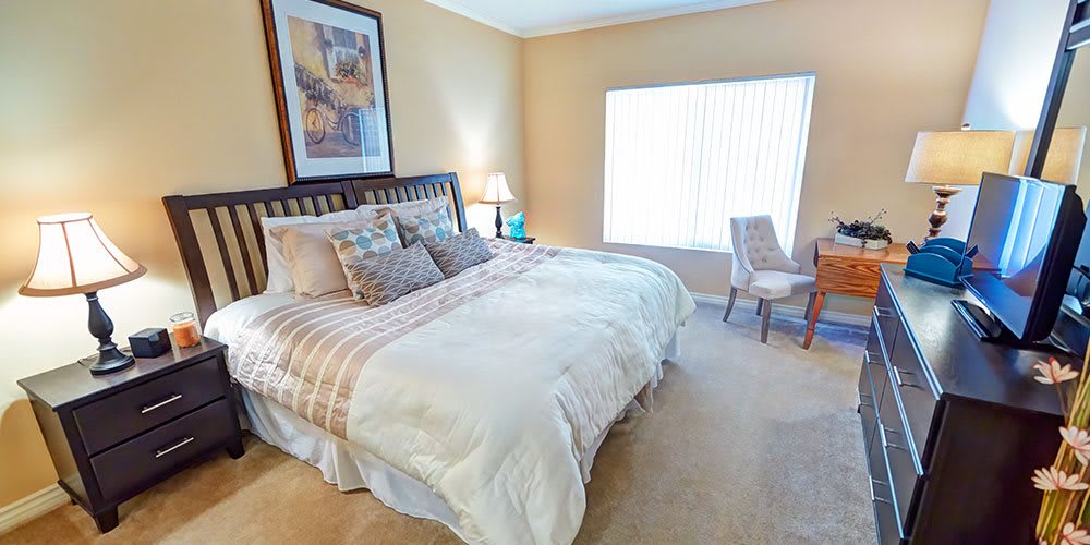 A cozy bedroom with a large bed, stylish decor, and natural lighting.