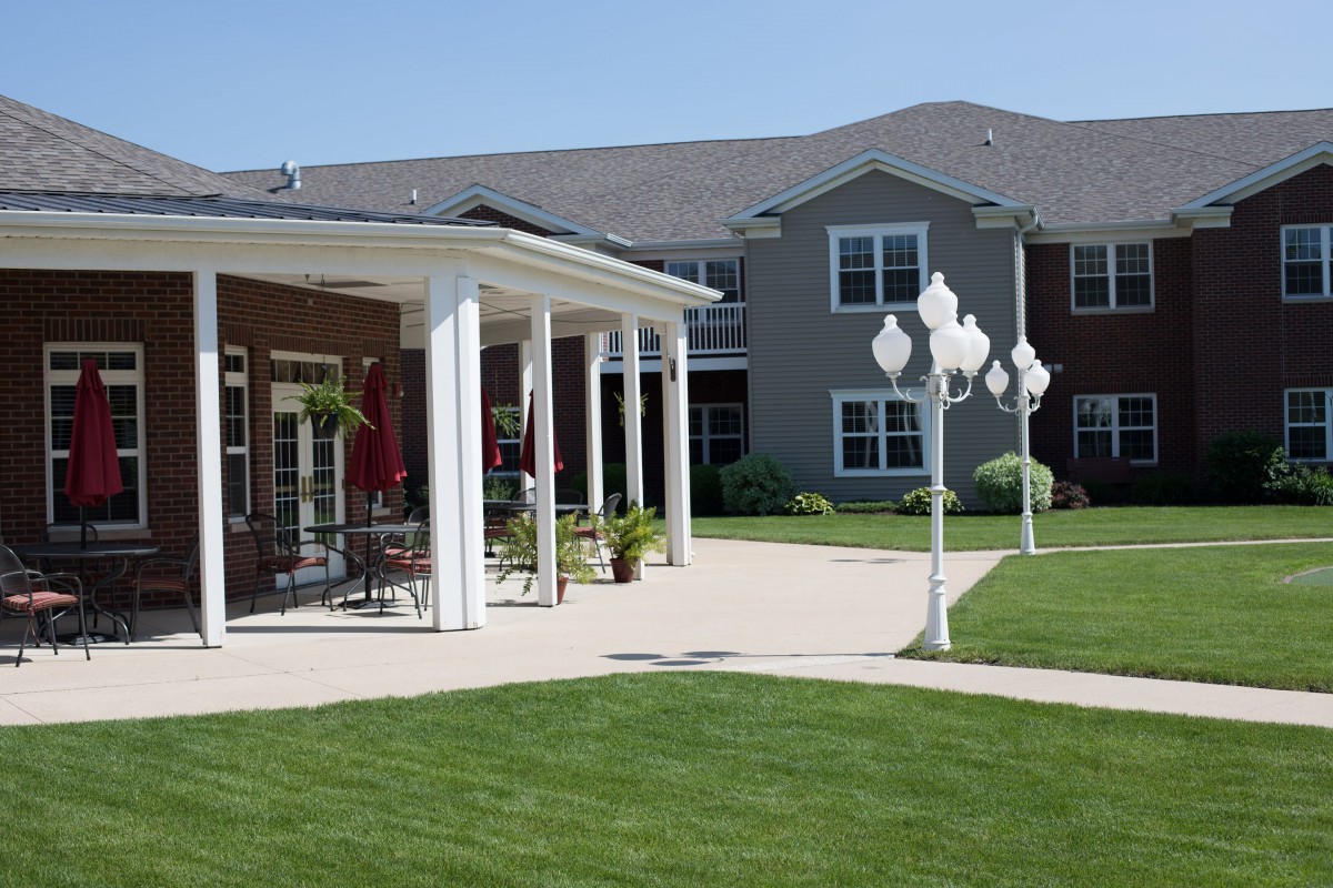 A modern residential building with a well-maintained lawn and patio area.