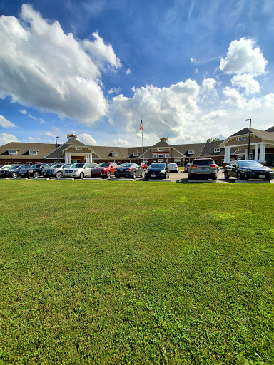 A view of a building with a spacious parking lot under a partly cloudy sky.