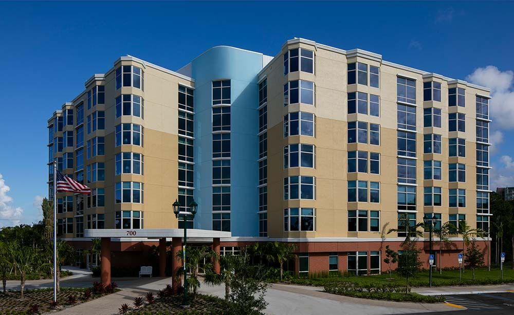 A modern multi-story building with a combination of blue and beige exterior.