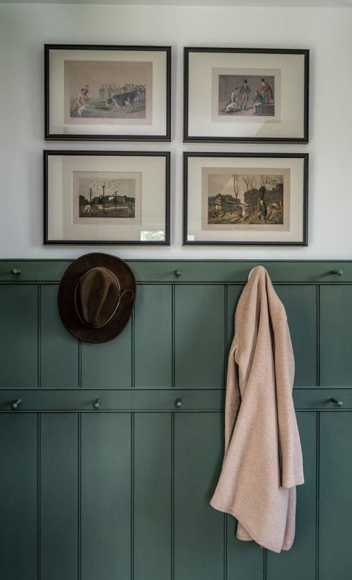 A cozy interior with framed pictures, a hanging hat, and a coat.