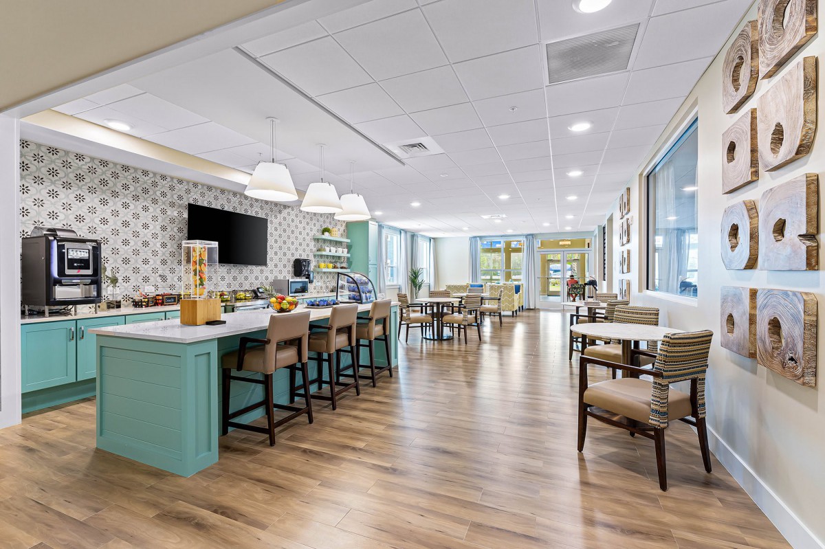 A modern and spacious dining area with wooden flooring, bar counter, and ample seating.