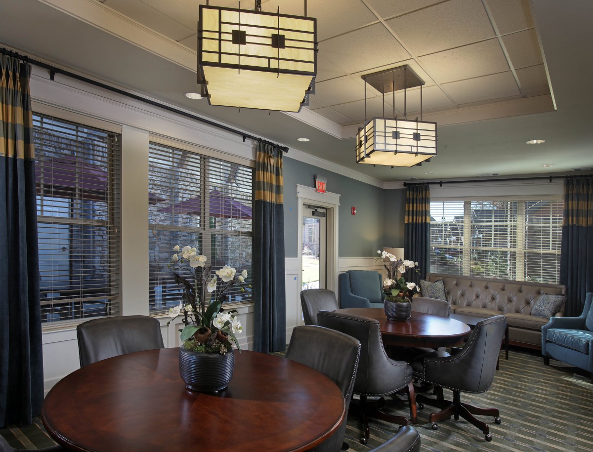 A modern meeting room with stylish lighting, round tables, and comfortable seating.