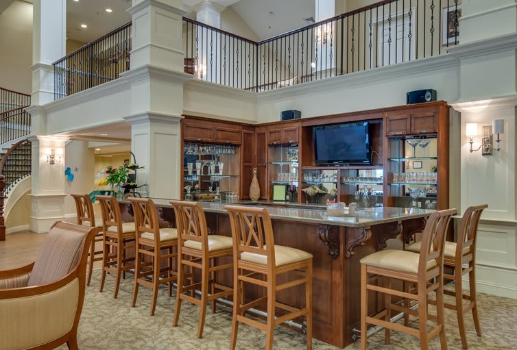 A spacious bar area with wooden chairs and a television in an open interior setting.