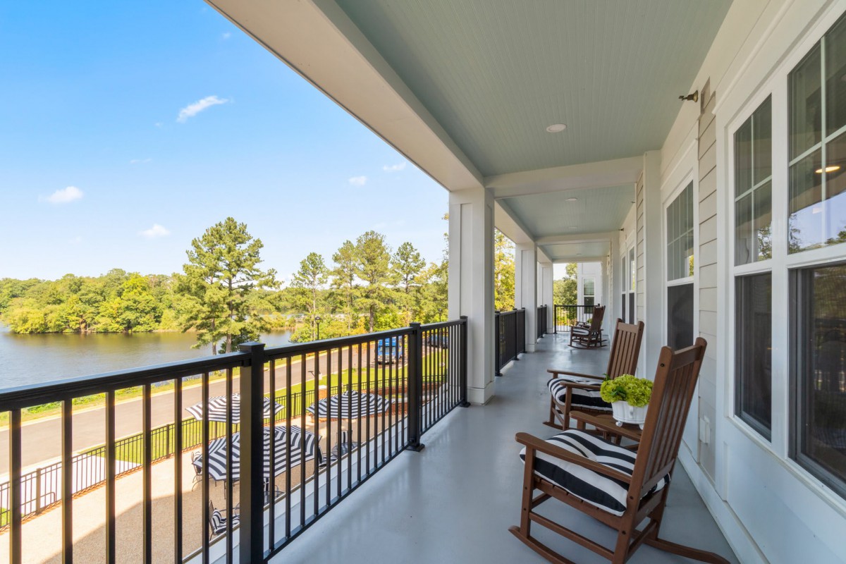 A spacious porch with rocking chairs overlooking a scenic outdoor view.