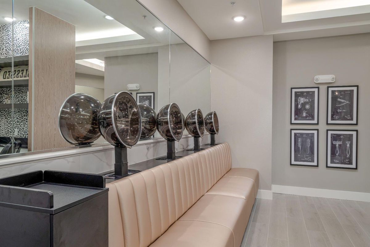 A modern salon interior featuring hair dryers and a comfortable seating area.