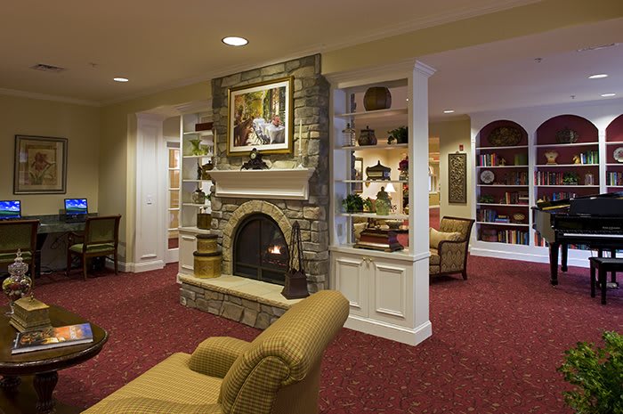 A cozy living room featuring a stone fireplace, comfortable seating, and built-in bookshelves.