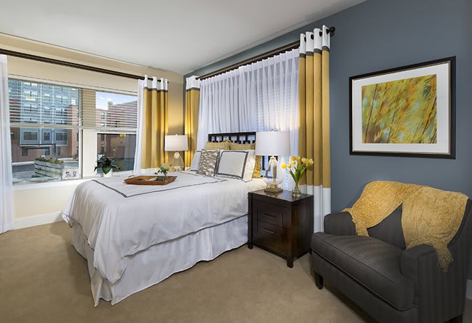 A modern and cozy bedroom featuring elegant decor with gold curtains, a comfortable bed, and stylish furniture.