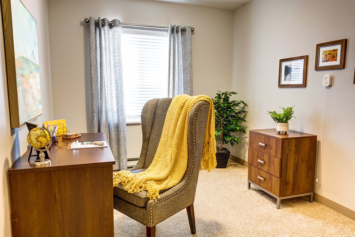A cozy office space with a desk, chair, and decorative elements.