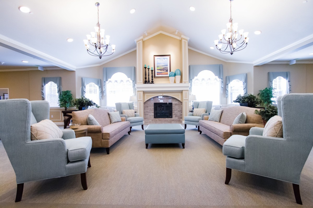 A spacious and bright living room with comfortable seating and elegant chandeliers.
