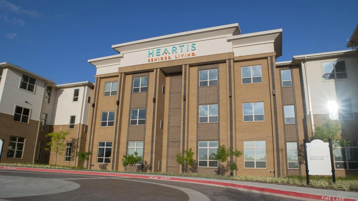 A residential apartment building with a modern architectural design, photographed during the daytime.