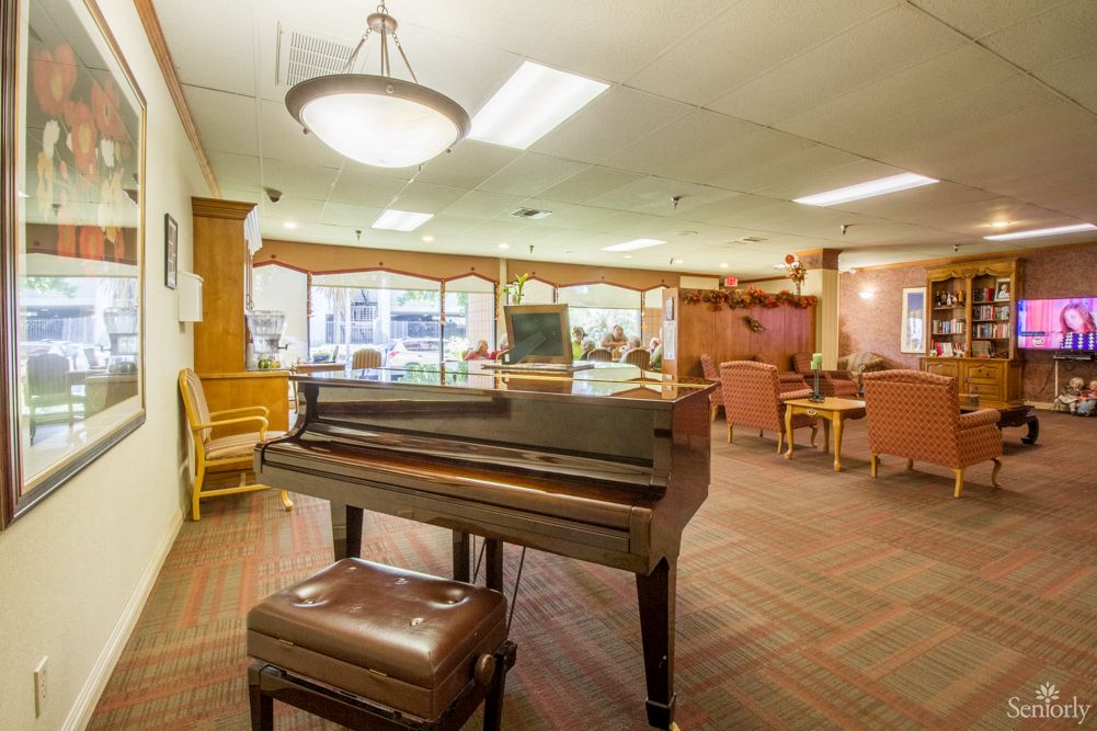 A cozy lounge area featuring a grand piano and comfortable seating arrangements.