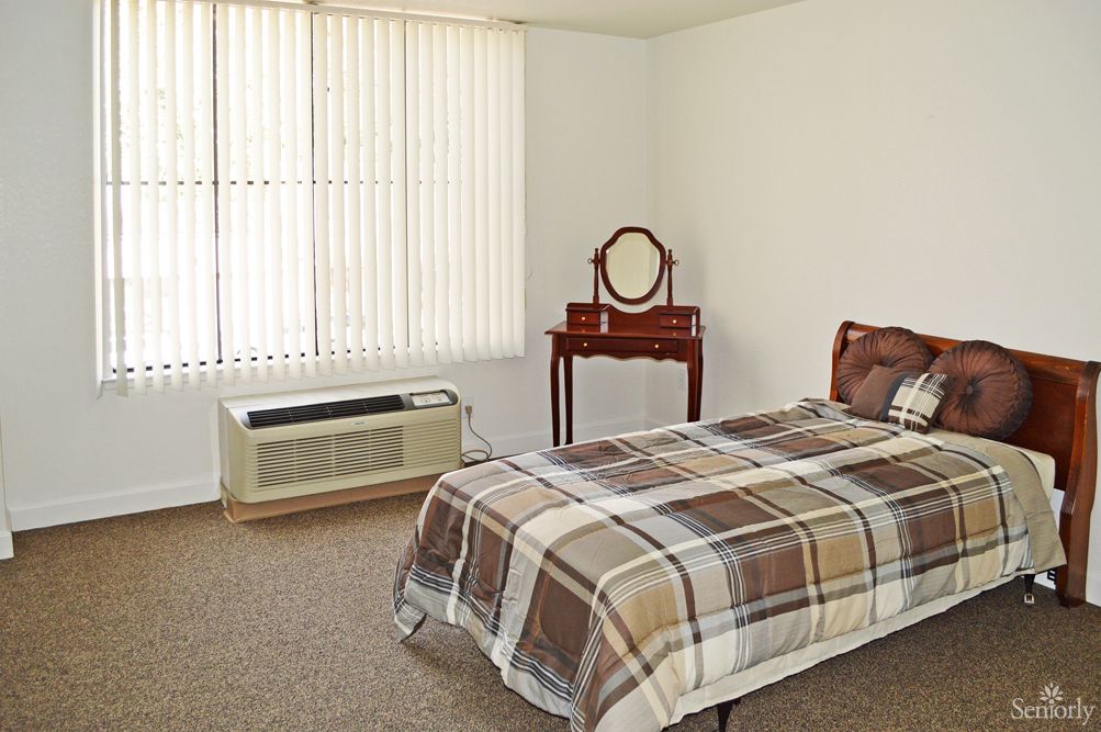 A simple bedroom with a single bed and a vintage dresser.
