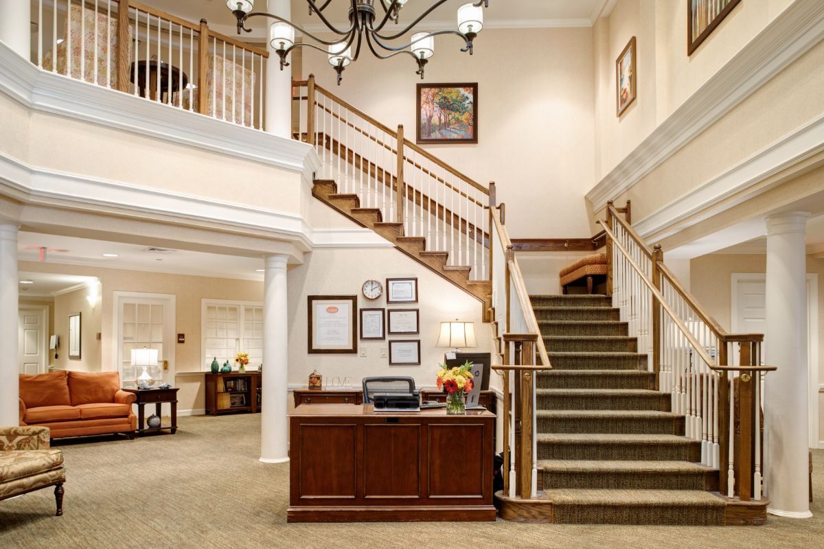 A cozy lobby interior with a reception desk and staircase leading to an upper level.