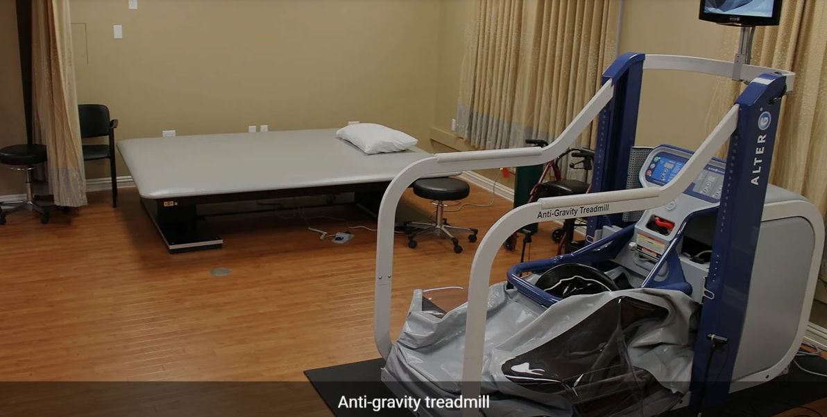 A room equipped with an anti-gravity treadmill used for rehabilitation and physical therapy.