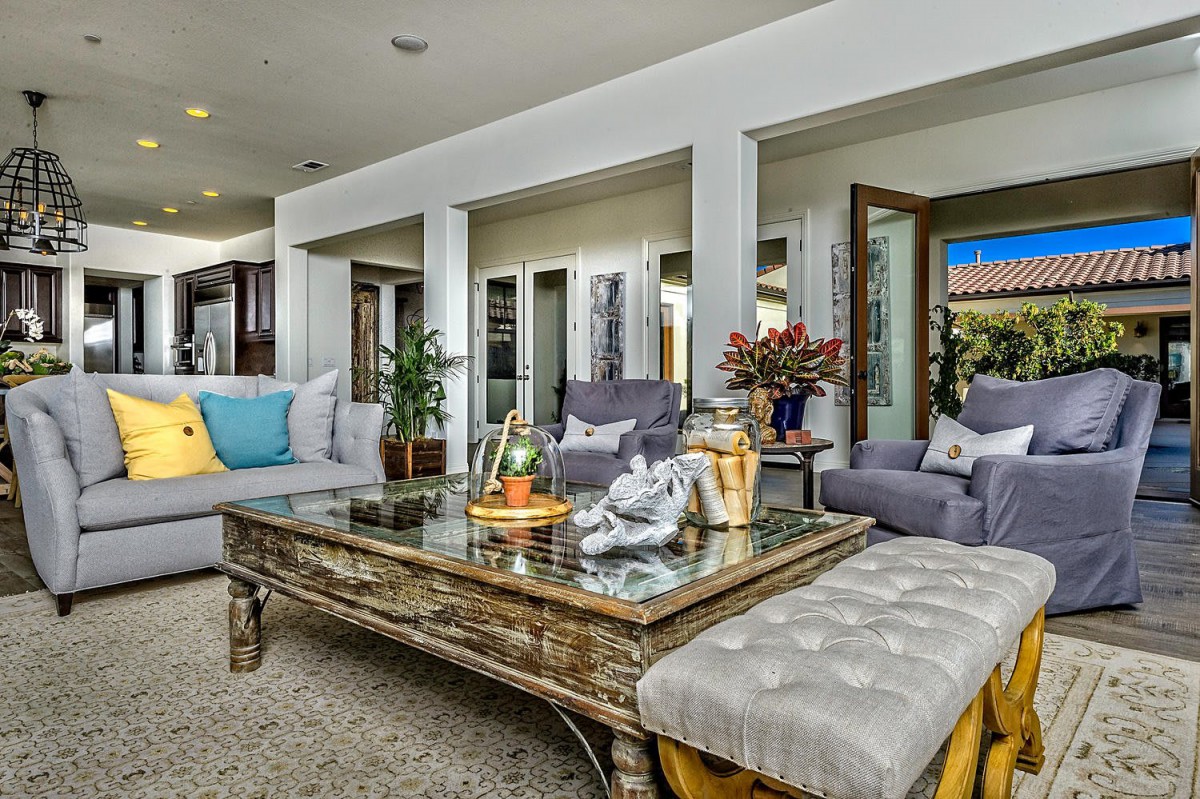 A stylish living room with comfortable seating, elegant decor, and a glass-topped coffee table.