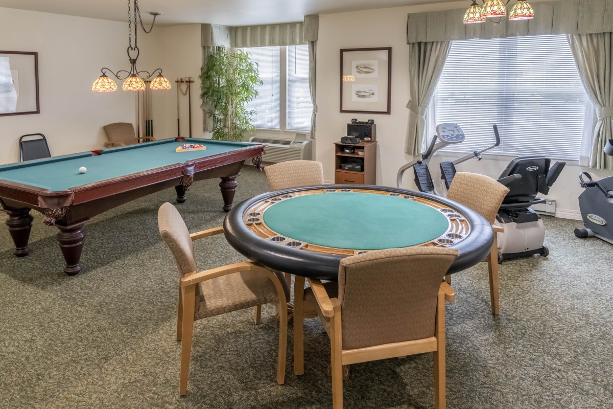 A cozy game room featuring a poker table and a pool table, perfect for leisure and social activities.