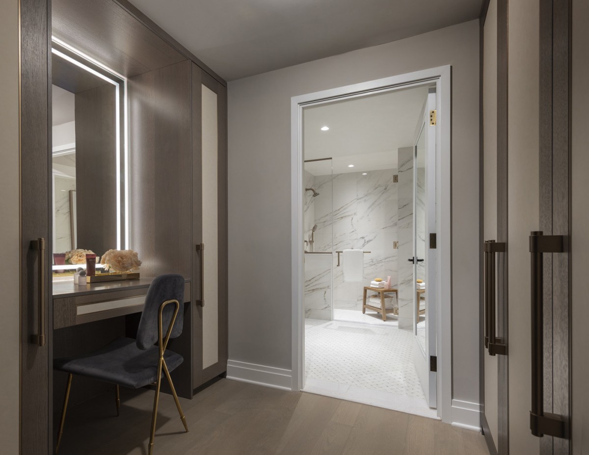 A modern and luxurious bathroom with a marble-tiled shower and elegant vanity area.